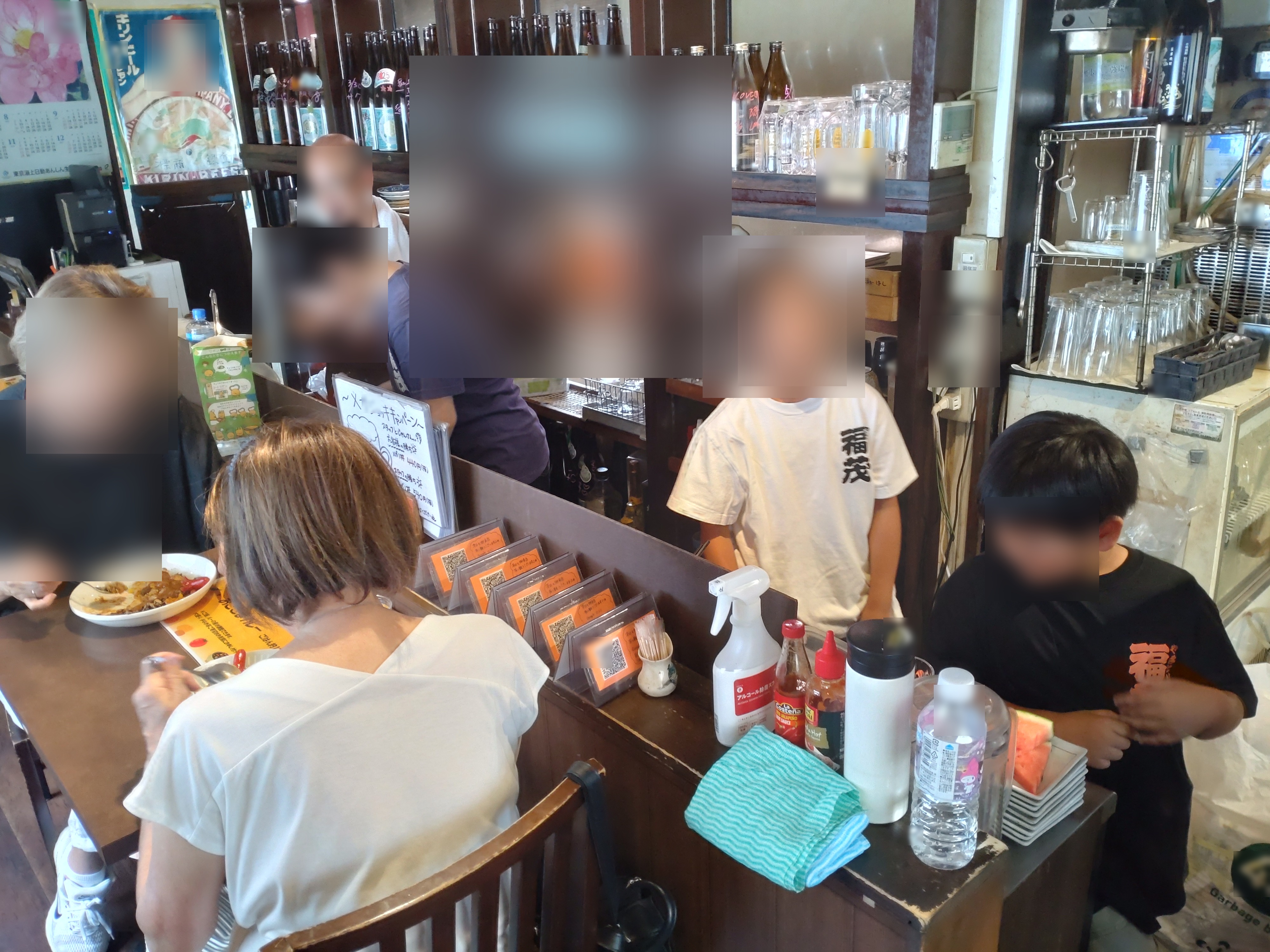 カウンターで手伝いをする子どもと、食事をする人たち