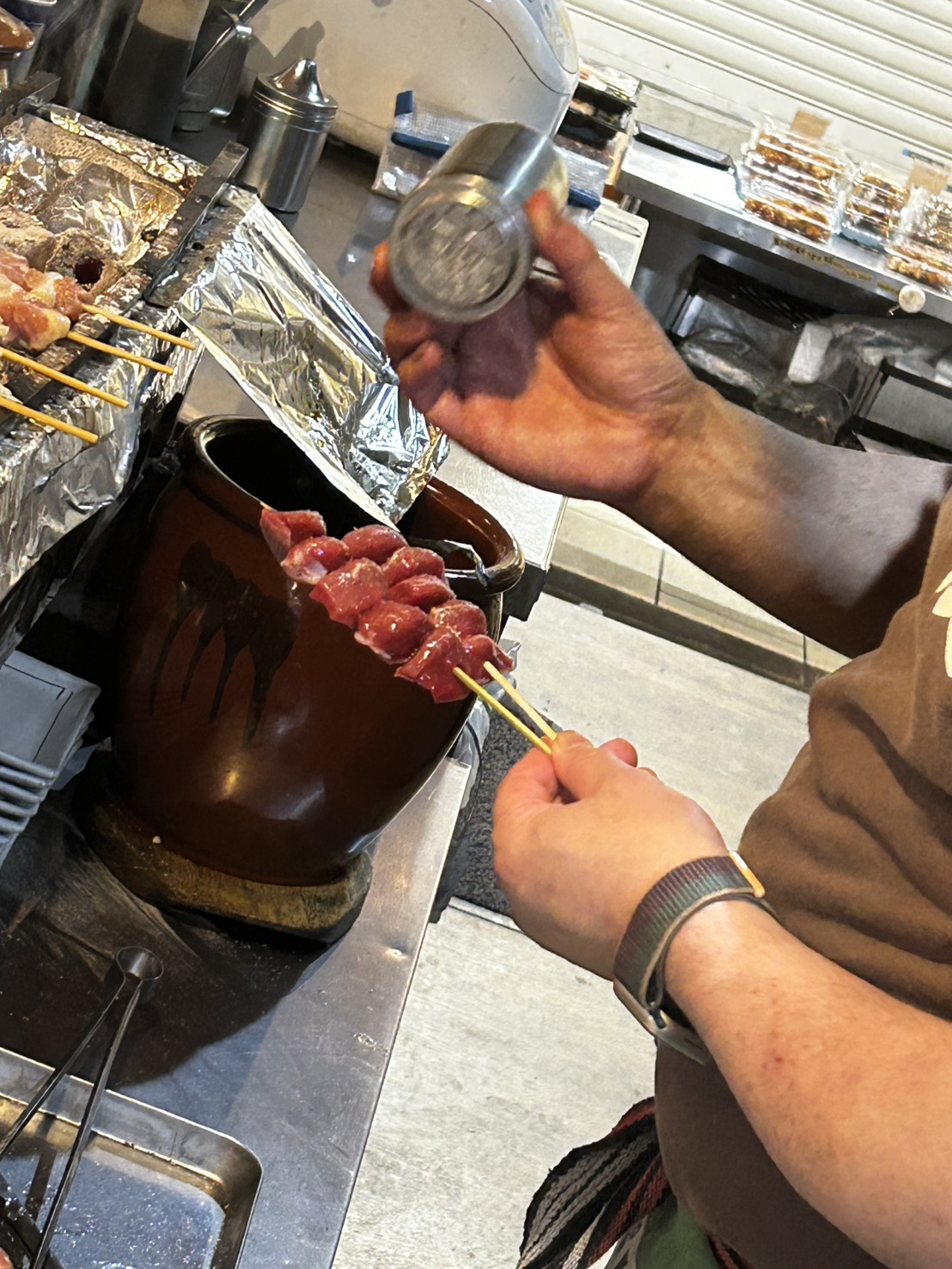 串に塩を振る焼き手の手元