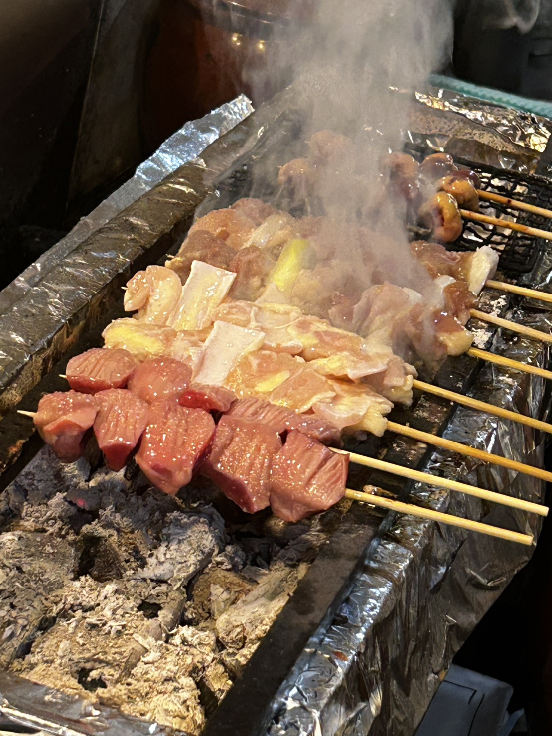 炭火の上で立ちのぼる煙と串